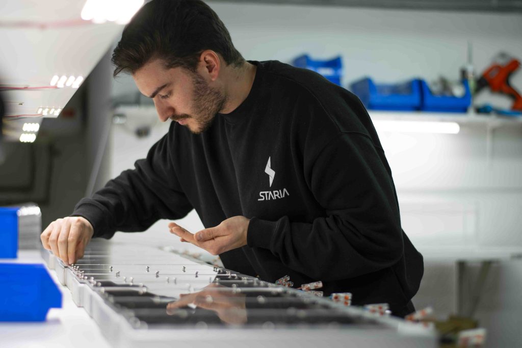 Ingeniero de Staria en la cadena de producción montando luminarias